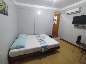 1 dormitorio con 1 cama y TV en JB Valdres Apartment en Manila