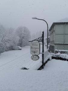 een straatbord in de sneeuw naast een straatlicht bij Villa Burgau B&B in Monschau