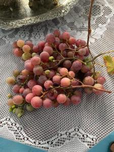 Um monte de uvas cor-de-rosa sentadas numa mesa. em Maison d'hôtes "Abou-Hachem" em Melaah