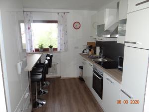 a kitchen with white cabinets and black appliances at Ferienwohnung Stein in Verrenberg