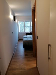 um corredor com uma cama e uma janela num quarto em PENSIÓN B2bIKAIN HSS00895 em Oiartzun