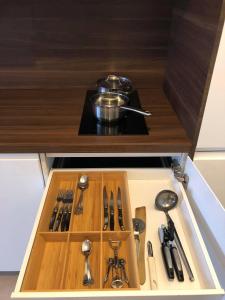 un cassetto in un armadio pieno di utensili da cucina di Apartment Fruithof Tack a Sint-Gillis-Waas