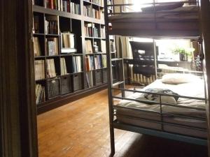 a bedroom with a bunk bed in a library at B&B Lady Jane in Bruges