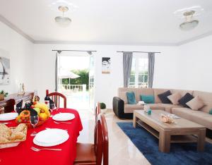 sala de estar con mesa roja y sofá en Townhouse Palm Beach by Algarve Vacation, en Albufeira