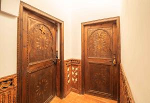 two large wooden doors in a room with a floor at Riad Rihana Dades in Boumalne