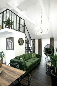 sala de estar con sofá verde y mesa en Luxury Loft, en Kaunas