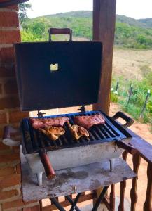 Chalé com Vista Privilegiada في Pilões: يوجد شواية عليها لحم