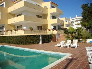 a villa with a swimming pool in front of a building at Mantamar Apartamentos in Manta Rota