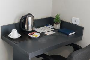 a black desk with a coffee maker and a tea kettle at Paulista Garden Hotel in Sao Paulo