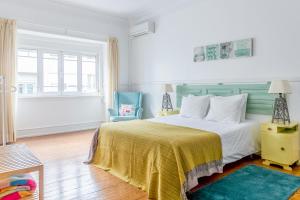 um quarto com uma cama grande e um cobertor amarelo em Casa da Avenida Lisboa em Lisboa