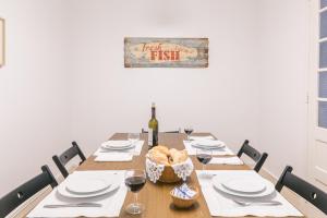 a table with a bottle of wine and a basket of bread at Casa da Avenida Lisboa in Lisbon