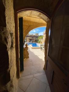 an archway in a building with a pool in the background at Warda Guest House in Xewkija