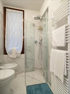 uma casa de banho com um chuveiro, um WC e um lavatório. em Canal Tron em Veneza