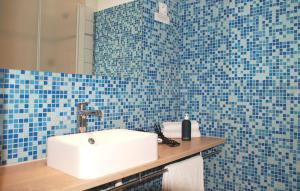 a bathroom with a white sink and blue tiles at Hôtel Du Port Et De L'aven in Névez