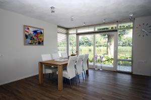 comedor con mesa de madera y sillas blancas en Swarte-Sluys, en Zwartsluis