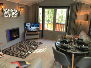 a living room with a table and a television at L11 - The Harlech Lodge with Hot Tub in Bethesda