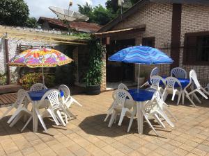 un grupo de mesas y sillas con sombrillas en Zizi Home en Chapada dos Guimarães