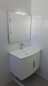 een badkamer met een witte wastafel en een spiegel bij Calle Goya 108 in Arguineguín