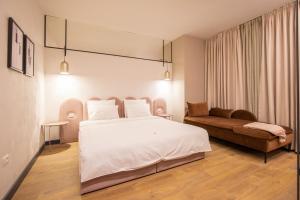 una camera con un grande letto e un divano di Allure Boutique Hotel a Tirana