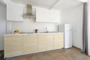 a kitchen with wooden cabinets and a white refrigerator at Casa Amanecer II in Mácher