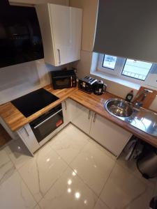 a small kitchen with a sink and a microwave at Umbrella Properties London Woolwich in London