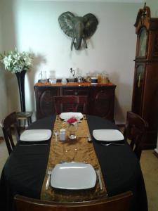 a dining room with a table and an elephant head on the wall at Europa Lodge in Welkom