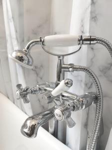 a chrome bathroom sink with a shower head at Umbrella Properties London Woolwich in London