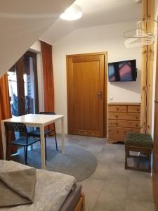 Pokoje Optima في يونيجوو: غرفة معيشة مع طاولة وغرفة نوم