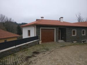 una casa con una puerta marrón y una pared de ladrillo en Casa das Olmedas, en Vimioso