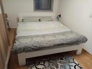a bed in a room with a white bed frame at FLAMANITA APARTMENTS in Skopje