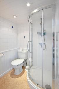 a bathroom with a toilet and a glass shower at The Wylfa in Abersoch