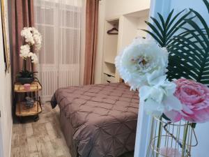 a bedroom with a bed and flowers in a room at L’ensoleillée in Nice