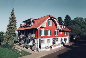Cette grande maison est décorée dans des tons rouges et blancs. dans l'établissement Hotel Haus am See, à Nonnenhorn