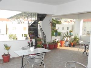 a patio with tables and chairs and potted plants at Pension Niki in Kalymnos