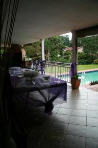 a patio with a table and a swimming pool at Firenze in Kloof