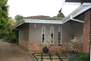 a small house with a potted plant in front of it at Firenze in Kloof