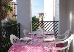 a table with a pink table cloth on a balcony at APARTAMENTO 1º LINEA DE PLAYA ZAHARA DE LOS ATUNES in Zahara de los Atunes