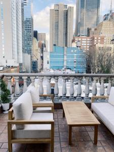 a balcony with chairs and tables and a city skyline at Hotel Scherman in New York