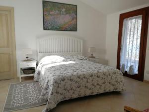 a bedroom with a bed and two tables and two windows at Lu Nidu in Olbia
