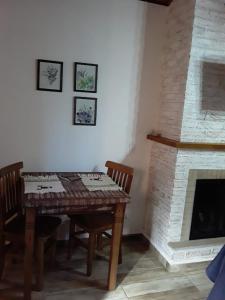 a dining room with a table and a fireplace at Chalé Safira in Monte Verde