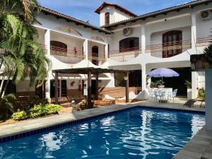 una villa con piscina frente a una casa en Pousada Pollyana, en Pirenópolis