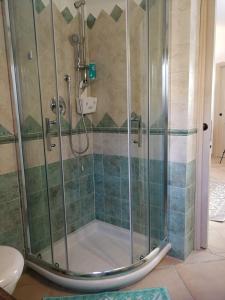 La salle de bains est pourvue d'une douche avec une porte en verre. dans l'établissement Lu Nidu, à Olbia