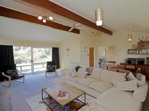 un soggiorno con divano bianco e tavolo di Kune Crib - Ohakune Holiday Home near Turoa a Ohakune