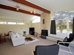 a living room with a white couch and a fireplace at Kune Crib - Ohakune Holiday Home near Turoa in Ohakune