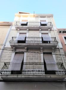 ein hohes Gebäude mit mehreren Fenstern und Sonnenkollektoren darauf in der Unterkunft Apartamentos Turísticos Tenor by Bossh Hotels in Barcelona