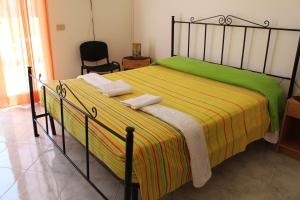 a bedroom with a bed with a green and yellow blanket at Villa Mozia in Marsala