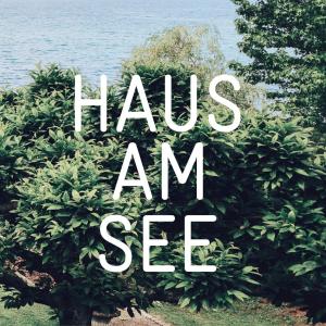 a bush with the words haus am see in front of the water at Hotel Haus am See in Nonnenhorn