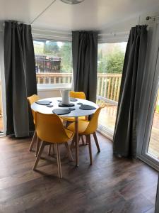 a dining room with a table and chairs and a balcony at Daffodil Lodge lovely 2 bedroom lodge no tradesmen or contractors in Builth Wells
