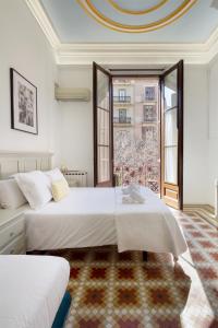 a bedroom with two beds and a large window at Hostal Girona in Barcelona