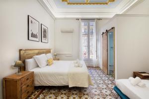 a bedroom with two beds and a window at Hostal Girona in Barcelona